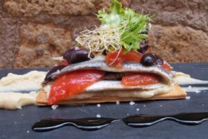Coca de seitons, puré de ceba tendra, tomàquets confitats i olives d’Aragó